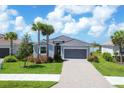New gray home with a tile roof, two-car garage, and lush landscaping, located on a quiet street at 14589 Ponce De Leon Trl, Port Charlotte, FL 33981