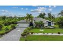 Single-story home with a large driveway and lush landscaping at 13703 Drysdale Ave, Port Charlotte, FL 33981