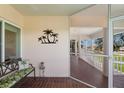 Inviting screened porch with a decorative bench, a palm tree design, and views of the lush surroundings at 11000 Placida Rd # 2303, Placida, FL 33946