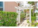 White pergola and pathway leading through lush greenery at 2375 N Beach Rd # 3B, Englewood, FL 34223