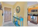Condo entryway with wood door and teal console table at 8413 Placida Rd # 407, Placida, FL 33946