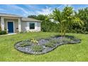 Landscaped front yard with a unique rock garden and a palm tree at 6047 Sunnybrook Blvd, Englewood, FL 34224