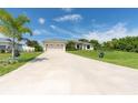 Long driveway leading to a two-car garage with landscaping on either side at 6047 Sunnybrook Blvd, Englewood, FL 34224