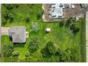 Expansive property with a house, large yard, and a storage shed, surrounded by lush greenery and a partially constructed building nearby at 13401 Galveston Ave, Port Charlotte, FL 33981