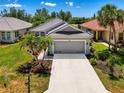 Well-maintained home features lush landscaping, a spacious driveway, and an attached garage with gray door at 3359 Osprey Ln, Port Charlotte, FL 33953