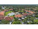 Aerial view of community with lake and condo buildings at 504 Pine Hollow Cir # 504, Englewood, FL 34223