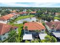 Aerial view of community with lake, lush landscaping, and condo buildings at 504 Pine Hollow Cir # 504, Englewood, FL 34223