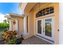 Elegant entryway with double doors and decorative glass, columns and landscaping at 247 Tournament Rd, Rotonda West, FL 33947