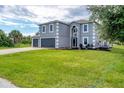 Two-story house with gray siding, attached garage, and landscaped lawn at 13401 Galveston Ave, Port Charlotte, FL 33981