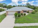 Single-story home with a gray roof and a well-maintained lawn at 7506 Spinnaker Blvd, Englewood, FL 34224
