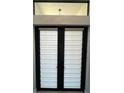 Modern front entry featuring double doors with integrated blinds at 13342 Commonwealth Ave, Port Charlotte, FL 33981