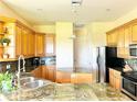 Well-equipped kitchen with wood cabinets, granite countertops, and stainless steel appliances at 324 Santurce Ave, North Port, FL 34287