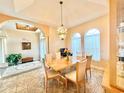 Elegant dining room with a large table, chandelier, and access to the kitchen at 324 Santurce Ave, North Port, FL 34287