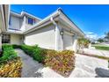 Front view of townhome showcasing a walkway and lush landscaping at 3363 Grand Vista Ct # 203, Port Charlotte, FL 33953