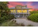 Back exterior view of the house showcasing a patio and lush landscaping at 22 Seawatch Dr, Boca Grande, FL 33921