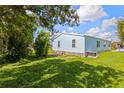 Manufactured home with grassy backyard and partial tree cover at 5704 Holiday Park Blvd, North Port, FL 34287