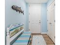 Bright entryway with a painted bench and tile flooring at 10055 Links Ln # 206, Rotonda West, FL 33947