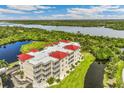 Aerial view of a waterfront condo building with red roofs at 10055 Links Ln # 206, Rotonda West, FL 33947