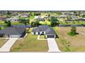 Picturesque single-story home nestled in a quiet neighborhood with a lake, well-kept lawn, and a gray roof at 220 Mark Twain Ln, Rotonda West, FL 33947