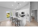 Bright kitchen features a large island with seating and white cabinets and modern appliances at 220 Mark Twain Ln, Rotonda West, FL 33947