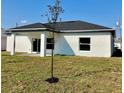 This backyard has an open lawn, a small patio area, and a young tree recently planted at 235 Albatross Rd, Rotonda West, FL 33947