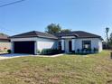 Attractive one-story house with dark gray roof, black trim, and green lawn at 235 Albatross Rd, Rotonda West, FL 33947