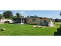 Spacious backyard with grassy lawn, screened patio, and storage shed at 1700 Morning Dove Ln, Englewood, FL 34224
