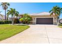 Tan house with brown garage door and palm trees at 4632 Arlington Dr, Placida, FL 33946