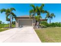 One-story home with attached garage and manicured lawn at 135 Cabana Way, Rotonda West, FL 33947