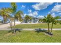 Gray house with palm trees, lush lawn, and a three-car garage at 13400 Buckett Cir, Port Charlotte, FL 33981