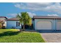 House exterior with a two car garage and palm tree in front at 612 Deerwood Ave # 169, Englewood, FL 34223