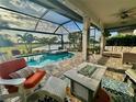 Relaxing screened patio with a beautiful pool, hot tub, and views of the pond at 13092 Rinella St, Venice, FL 34293