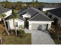 Beautiful aerial shot of a single Gathering home showcasing dark roof and an attached two-car garage at 19060 Moscato Ct, Venice, FL 34293