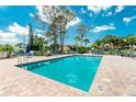 Inviting community pool with lounge chairs and patio area at 514 Pine Hollow Cir # 514, Englewood, FL 34223