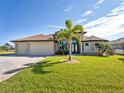 Lovely home showcasing a lush green lawn, a circular driveway, a three-car garage, and an elegant arched entryway framed by columns at 849 Rotonda Cir, Rotonda West, FL 33947
