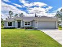 Gray house with a 2 car garage and well manicured lawn at 2775 Wyola Ave, North Port, FL 34286