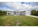 Single-story home with attached garage and grassy yard at 19196 Raymond Ave, Port Charlotte, FL 33954