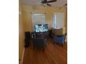 Living room with hardwood floors, two armchairs, and a large TV at 2704 Suncoast Lakes Blvd, Punta Gorda, FL 33980
