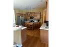 Kitchen with wood cabinets, stainless steel appliances, and an island at 2704 Suncoast Lakes Blvd, Punta Gorda, FL 33980