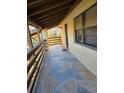 Covered balcony with stone tile flooring at 26 Quails Run Blvd # 7, Englewood, FL 34223