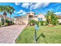 One-story house with a brick driveway and lush landscaping at 13033 N Marsh Dr, Port Charlotte, FL 33953