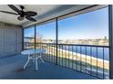 Screened balcony overlooking the water with a small table and chairs at 150 Englewood Isles Pkwy # 206, Englewood, FL 34223