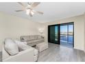 Living room with light beige sofa, gray flooring, and water views at 150 Englewood Isles Pkwy # 206, Englewood, FL 34223