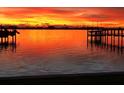 Stunning sunset over calm water with waterfront dock at 108 Winson Ave, Englewood, FL 34223