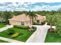 Single-story home with tile roof, two-car garage, and landscaped yard at 2844 Myakka Creek Ct, Port Charlotte, FL 33953