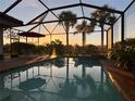 Screened in pool with beautiful sunset view, lounge chairs, and a small spa at 15048 Spanish Point Dr, Port Charlotte, FL 33981