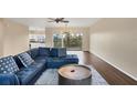 Living room featuring a blue sectional sofa, wood floors, and access to a balcony at 3929 Cape Haze Dr # 105, Rotonda West, FL 33947