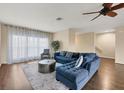 Living room with blue sectional sofa, wood floors, ceiling fan, and large windows at 3929 Cape Haze Dr # 105, Rotonda West, FL 33947