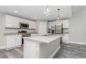 Modern kitchen with island and stainless steel appliances at 148 Lime Tree Park, Rotonda West, FL 33947