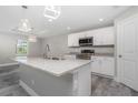 Modern kitchen with island, white shaker cabinets, granite countertops, and stainless steel appliances at 110 Glades Dr, Rotonda West, FL 33947